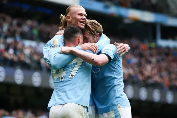 Erling Haaland of Manchester City celebrates with Kevin De Bruyne and Phil Foden after scoring his side's second goal vs Everton